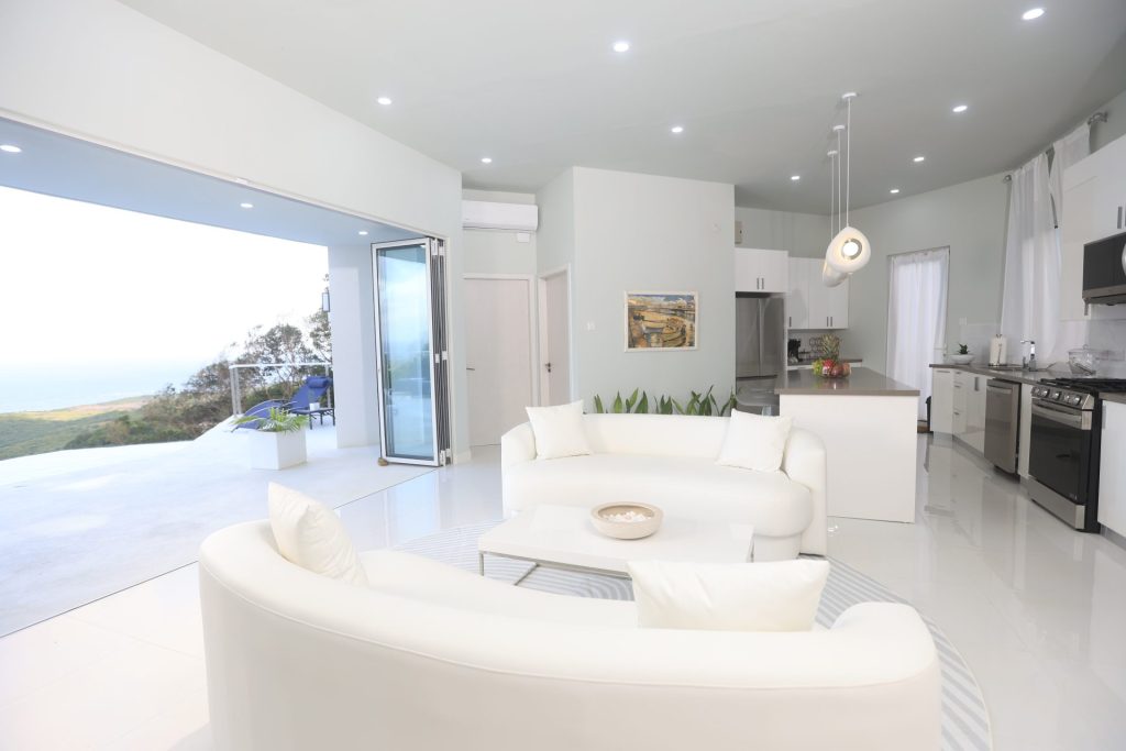 Elegant living area with curved white sofas and panoramic ocean view