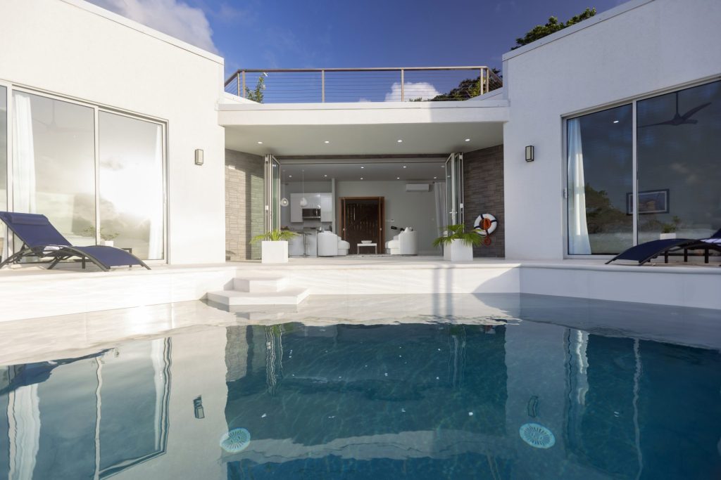 Modern luxury bathroom with marble walls, freestanding bathtub, and large window